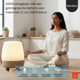 Woman meditating in a modern living room with a portable device and JBL branding.