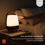 Lamp on a table with a person reaching out, in a cozy room setting.