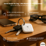 Xenon Smart Air Tag on a table with keychain, phone, and glasses in the background.